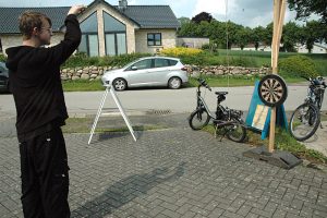 Museumstag 2025 Ein junger, in schwarz gekleideter Mann, spielt eine altes Dartsspiel.