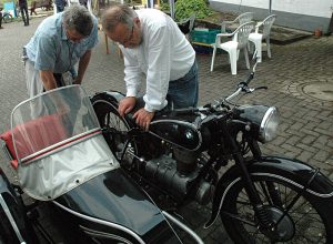 Museumstag 2025 Zwei Männer gebeugt über eine alte BMW mit Beiwagen.