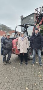 Weihnachtsbaumschmücken Foto: Goedecke Eine Frau und zwei Männer stehen vor dem Weidemann und lächeln in die Kamera.