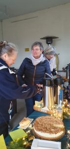 Weihnachtsbaumschmücken Foto: Goedecke Drei Frauen holen sich Kaffee aus Thermoskannen.