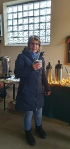 Weihnachtsbaumschmücken Foto: Goedecke Eine Frau mit Kaffeebecher in der Hand im blauen Anorak.