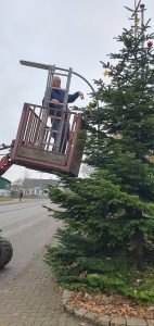 Weihnachtsbaumschmücken Foto: Goedecke Carsten Andresen im Weidemann wird nach oben zum Baumschmücken gefahren.
