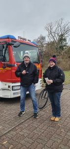 Weihnachtsbaumschmücken Foto: Goedecke Eine Frau und ein Mann vor dem Feuerwehrauto lächeln in die Kamera.