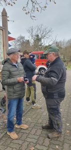 Weihnachtsbaumschmücken Foto: Goedecke Der Bürgermeister im Gespräch mit einem Mann. Dahinter ein Mann mit Baby und ein Feuerwehrauto.