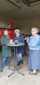 Weihnachtsbaumschmücken Foto: Goedecke Drei Frauen beim Kaffeetrinken am Stehtisch im Feuerwehrgerätehaus.