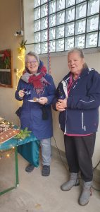 Weihnachtsbaumschmücken Foto: Goedecke Zwei Frauen am Kuchenbuffet lächeln in die Kamera.