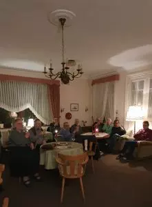 Lesung 2026 Gäste der Lesung im Vorsaal mit einem Glas Sekt.