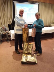 Reisebericht Patagonien Sie sehen Joachim Spengler und Birgit Kiehn-Schmeling bei der Übergabe eine Geschenkes. Im Vordergrund alte Schiffsteile der Feuerland.