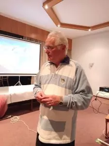 Sie sehen Joachim Spengler während des Vortages in einem weiß-blau gestreiften Shirt.