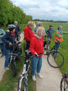 Radtour Mai 2026 Teilnehmende der Radtour blicken auf ein Feld.