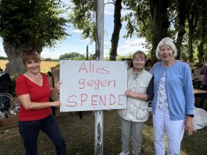 Flohmarkt 2026 Foto Wallenstein (9) Drei Frauen halten ein Schild mit der Aufschrift: "Alles gegen Spende".